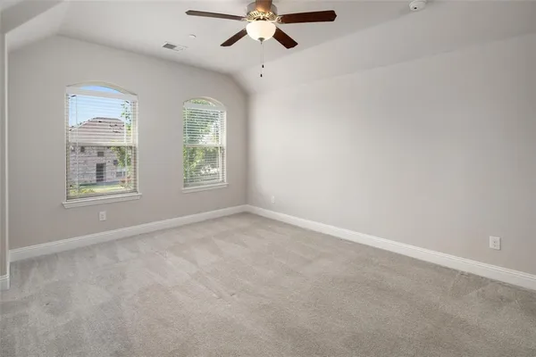 an empty room with windows and fan