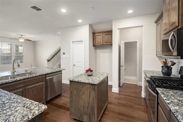 a kitchen with granite countertop a sink stove and cabinets