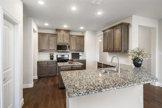 a kitchen with stainless steel appliances granite countertop a sink stove and refrigerator
