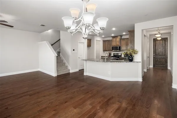 a view of a room with wooden floor and chandelier