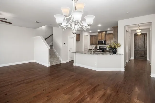 a view of a room with wooden floor and chandelier