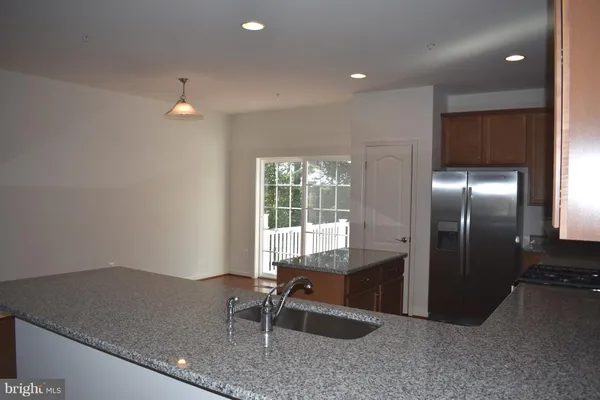 a kitchen with granite countertop a sink and a refrigerator