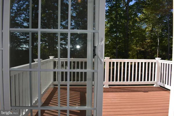 a view of a balcony with a floor to ceiling window and wooden fence