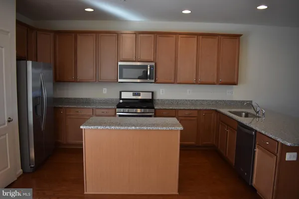 a kitchen with wooden cabinets and stainless steel appliances