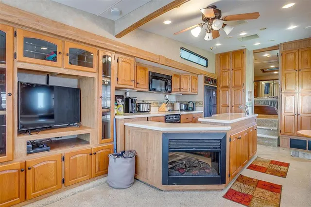 a large kitchen with stainless steel appliances granite countertop a large counter top a stove and a refrigerator