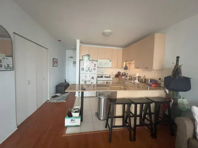 a room with kitchen island a dining table and chairs