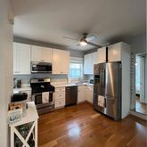 a kitchen with granite countertop a refrigerator and a stove top oven
