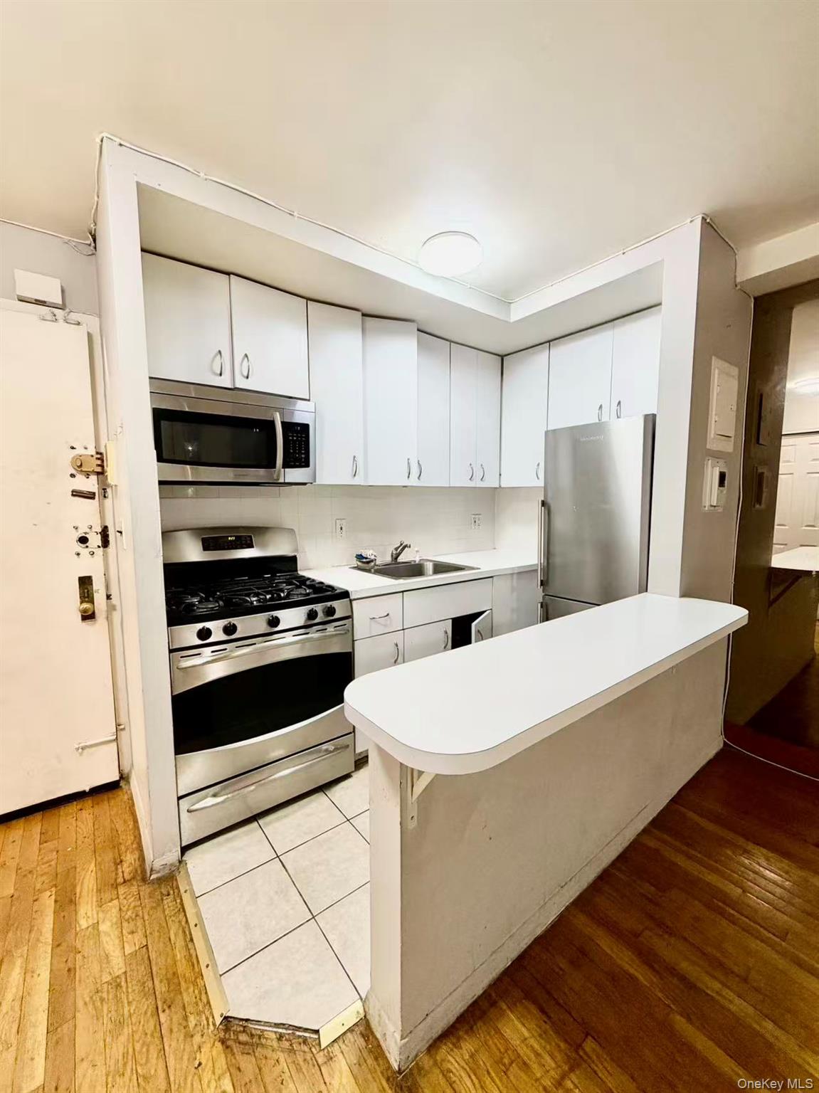 87-14 57th Road, Unit 3B Queens, NY 11373 - Photo 7 of 14 a kitchen with stainless steel appliances a refrigerator sink and stove