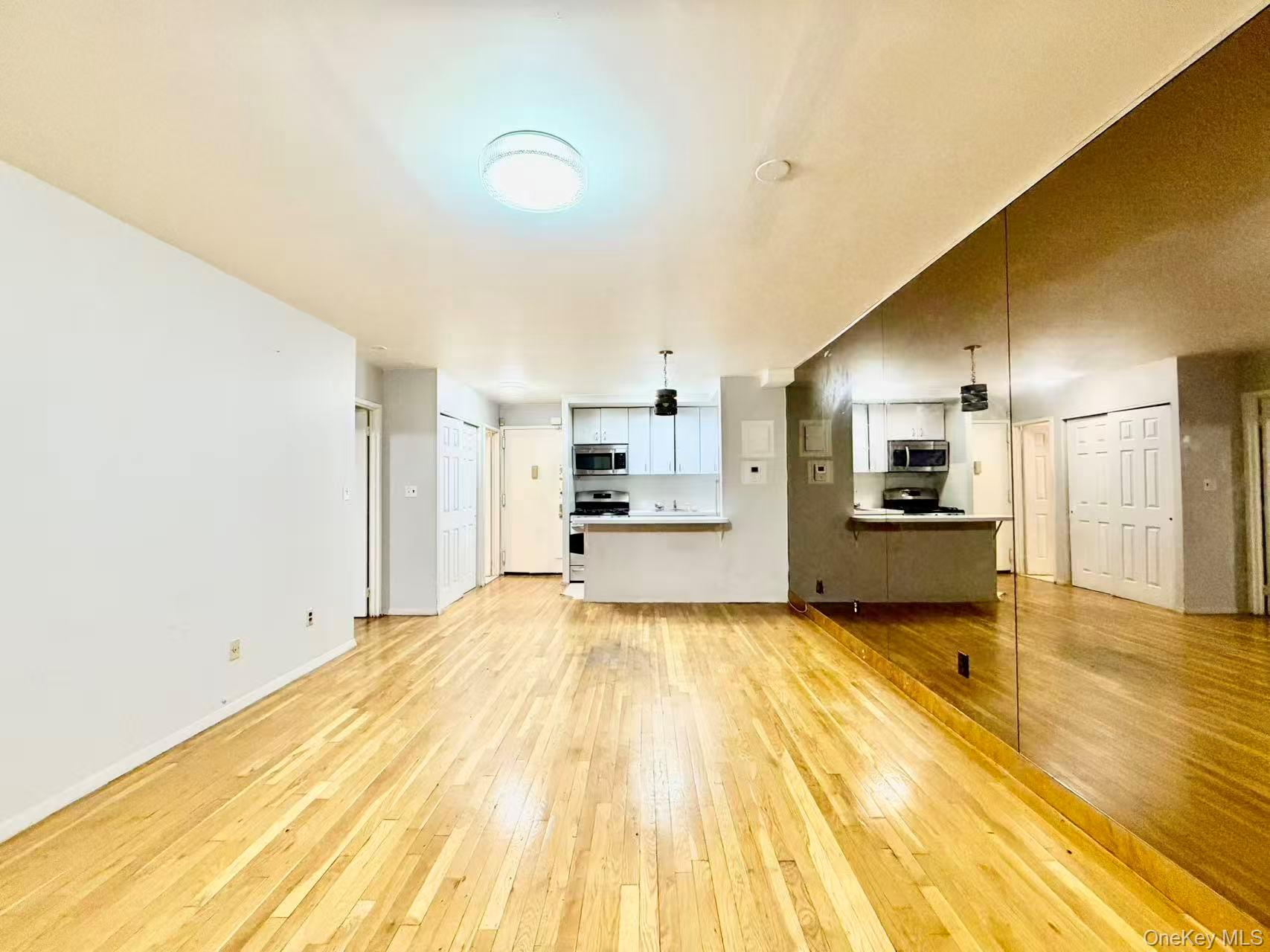 87-14 57th Road, Unit 3B Queens, NY 11373 - Photo 8 of 14 a large kitchen with a sink and cabinets