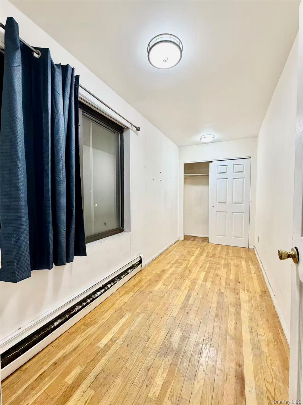 87-14 57th Road, Unit 3B Queens, NY 11373 - Photo 10 of 14 a view of a room with a wooden floor