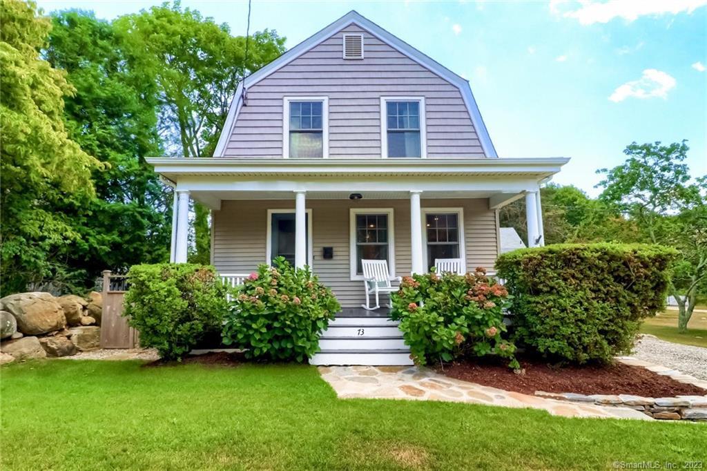 a front view of a house with a garden and plants
