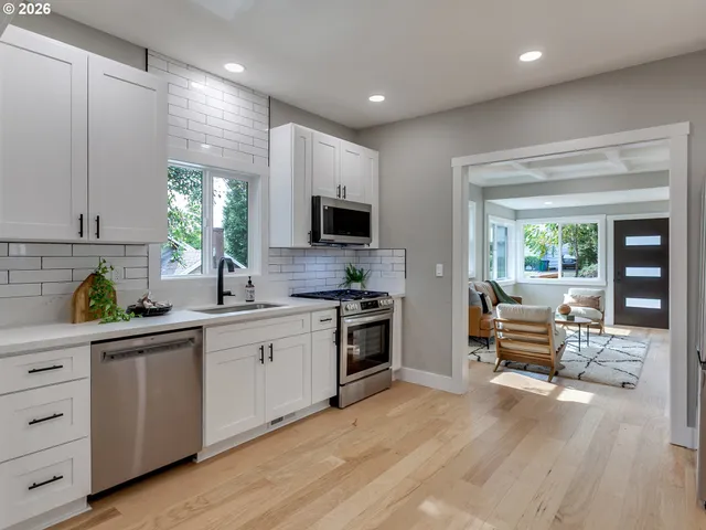 a kitchen with white cabinets and black stainless steel appliances
