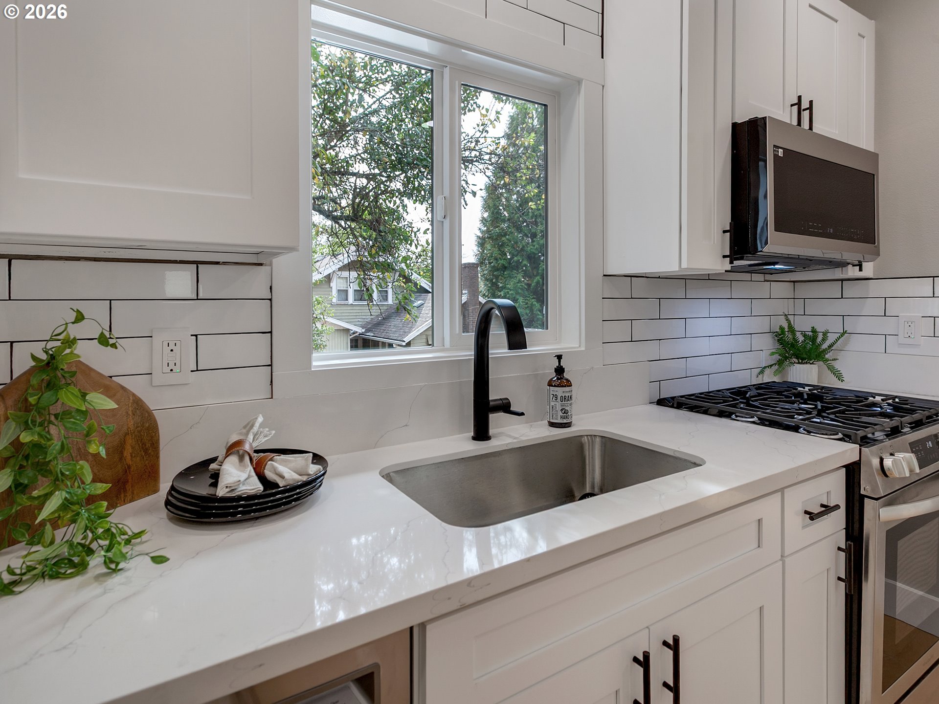 7224 Southwest 3rd Avenue Portland, OR 97219 - Photo 16 of 42 a kitchen with stainless steel appliances a sink a stove and a microwave