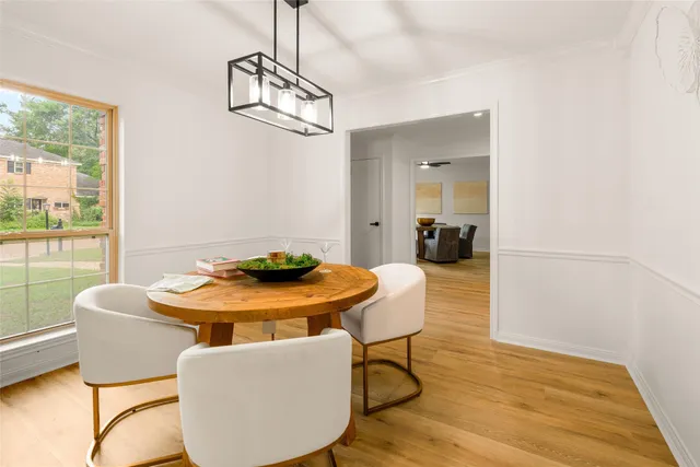 a dining room with furniture a chandelier and wooden floor