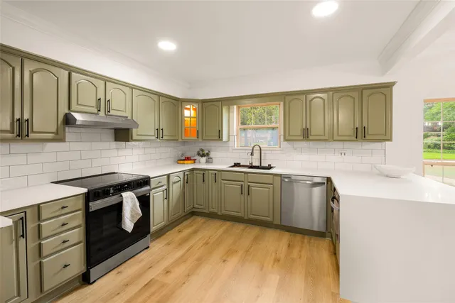 a kitchen with stainless steel appliances granite countertop a sink stove and cabinets