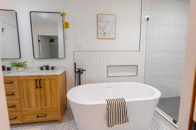 a bathroom with a tub sink and mirror
