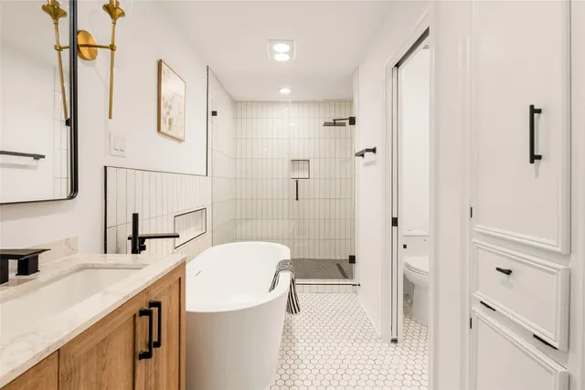 a bathroom with a granite countertop sink a toilet and shower