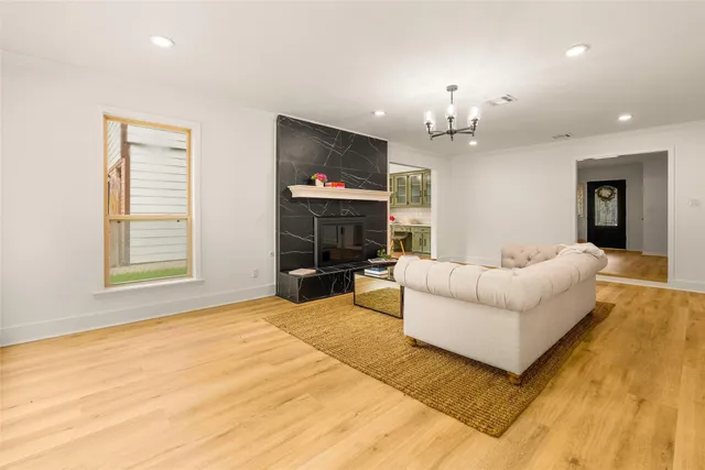a living room with furniture a fireplace and a chandelier