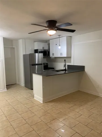 a kitchen with granite countertop a stove a sink and a refrigerator