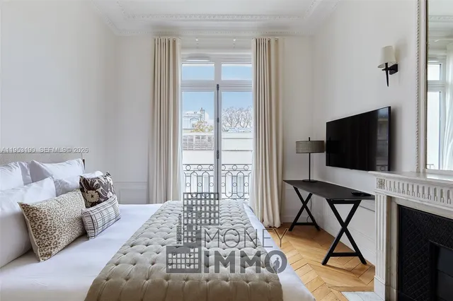 a bedroom with a bed and a flat tv screen on dresser