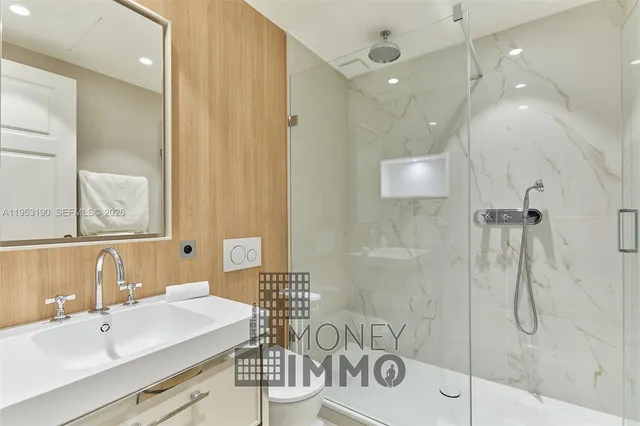 a bathroom with a sink shower and a mirror