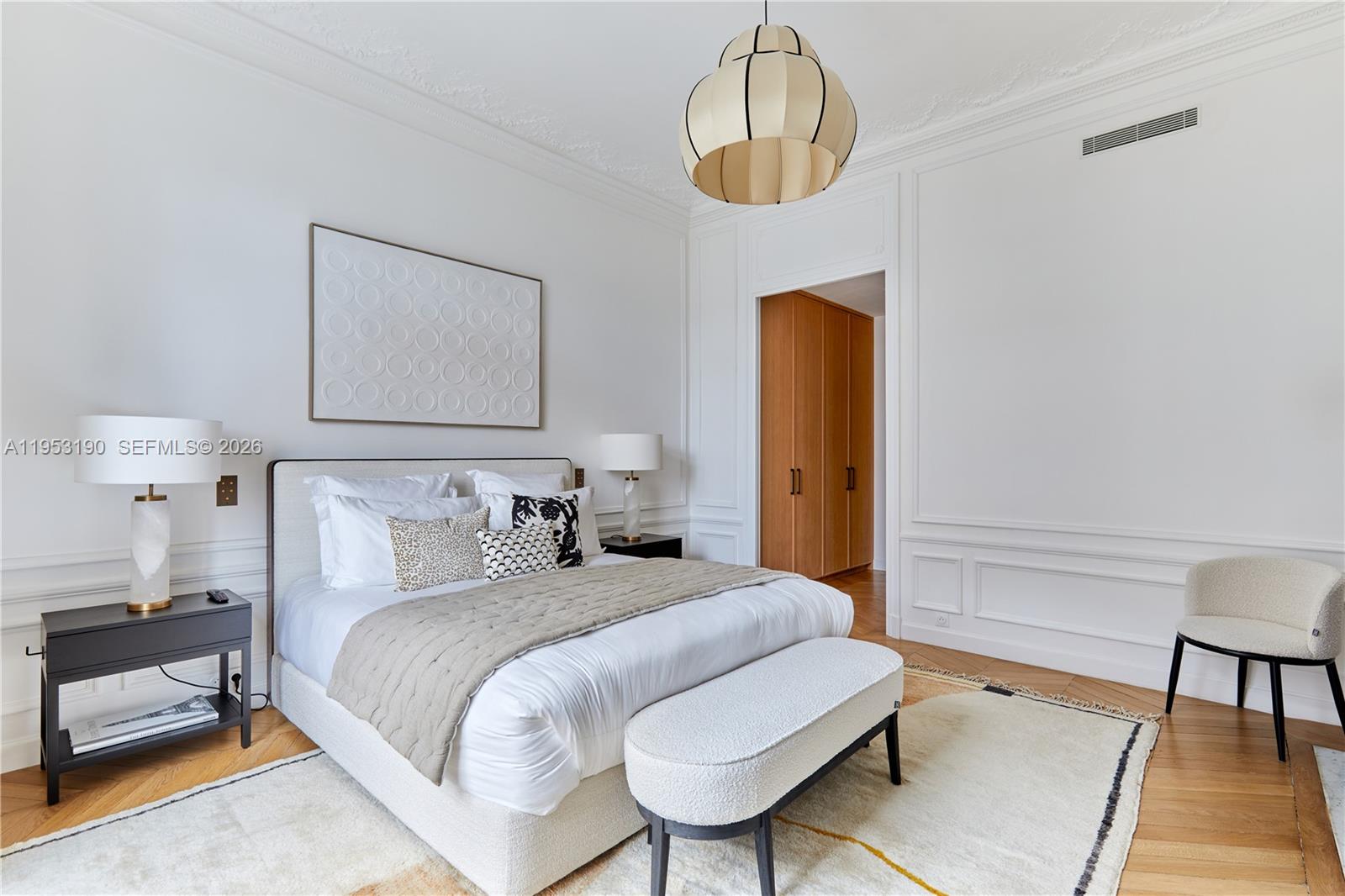 11 Rue Saint-Dominique, Unit SDO 403 Carrollton, IDF 75007 - Photo 34 of 40 a bedroom with a bed and a chandelier