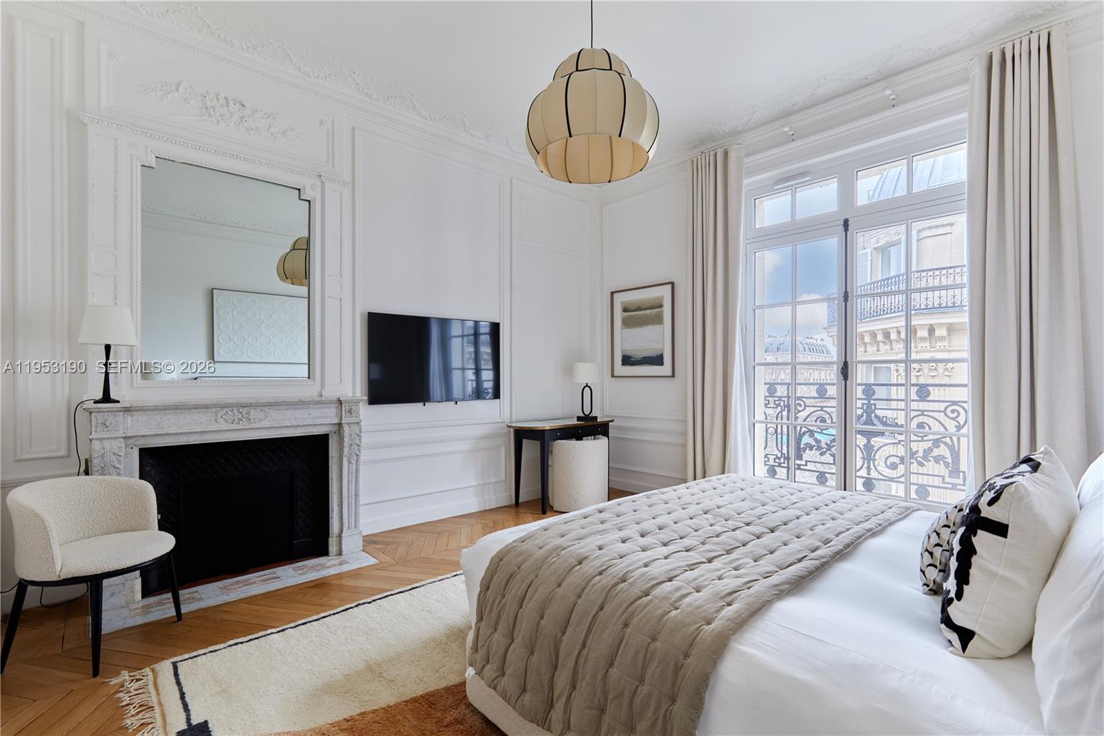 11 Rue Saint-Dominique, Unit SDO 403 Carrollton, IDF 75007 - Photo 37 of 40 a bedroom with a bed and a chandelier