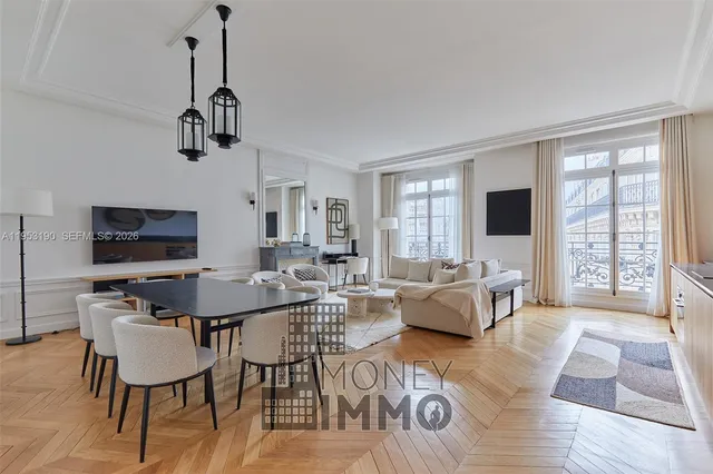 a view of a livingroom and dining room with furniture wooden floor a chandelier