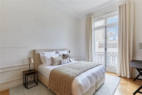 a bedroom with a bed and a large window