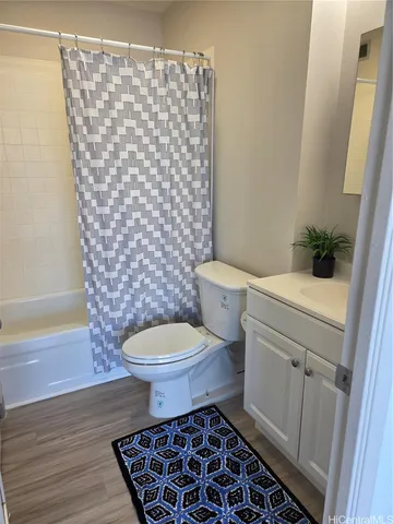 a bathroom with a toilet and a shower curtain