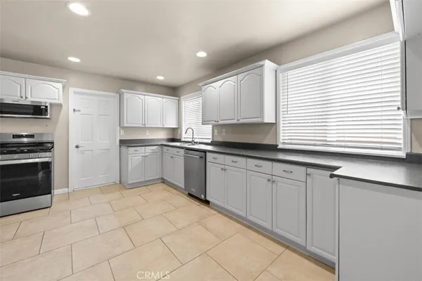 a kitchen with stainless steel appliances granite countertop a sink and a stove