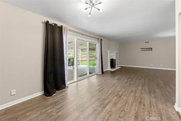 an empty room with wooden floor and a window
