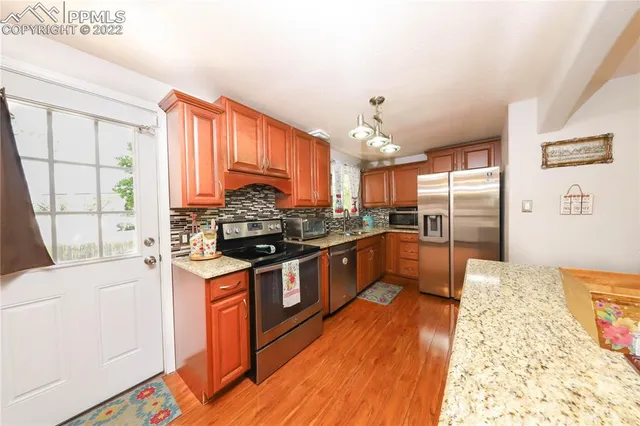 a kitchen with stainless steel appliances granite countertop a stove a sink dishwasher and a refrigerator