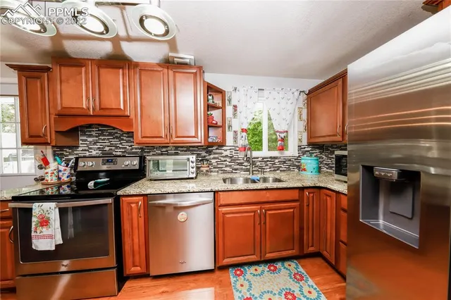 a kitchen with stainless steel appliances granite countertop a stove a sink and a microwave