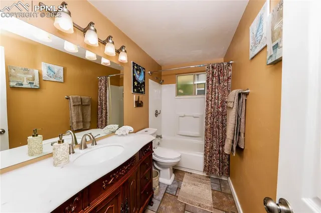 a spacious bathroom with a sink a toilet a mirror a vanity and shower