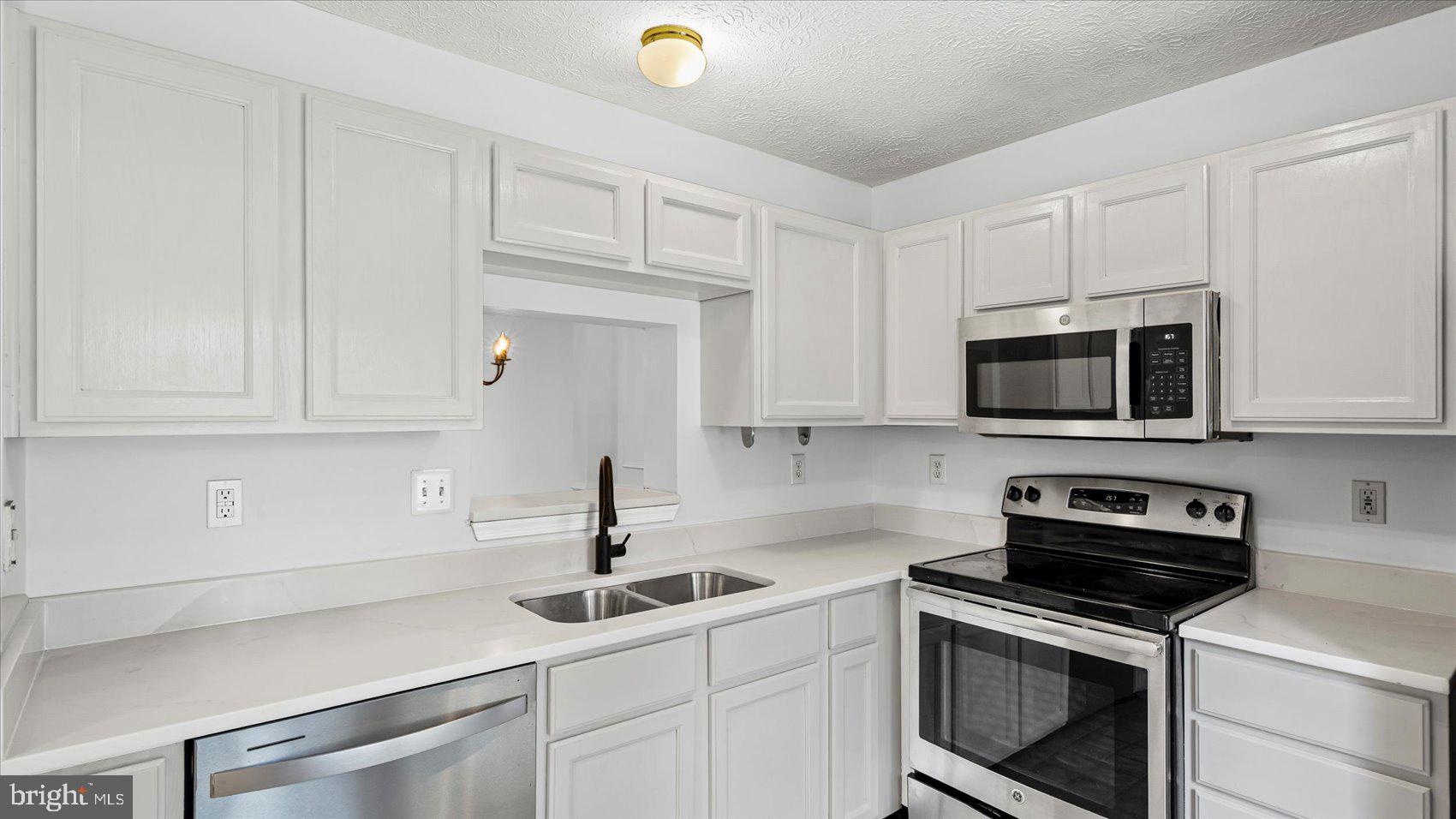 5108 Windermere Circle Baltimore, MD 21237 - Photo 6 of 38 a kitchen with white cabinets and stainless steel appliances
