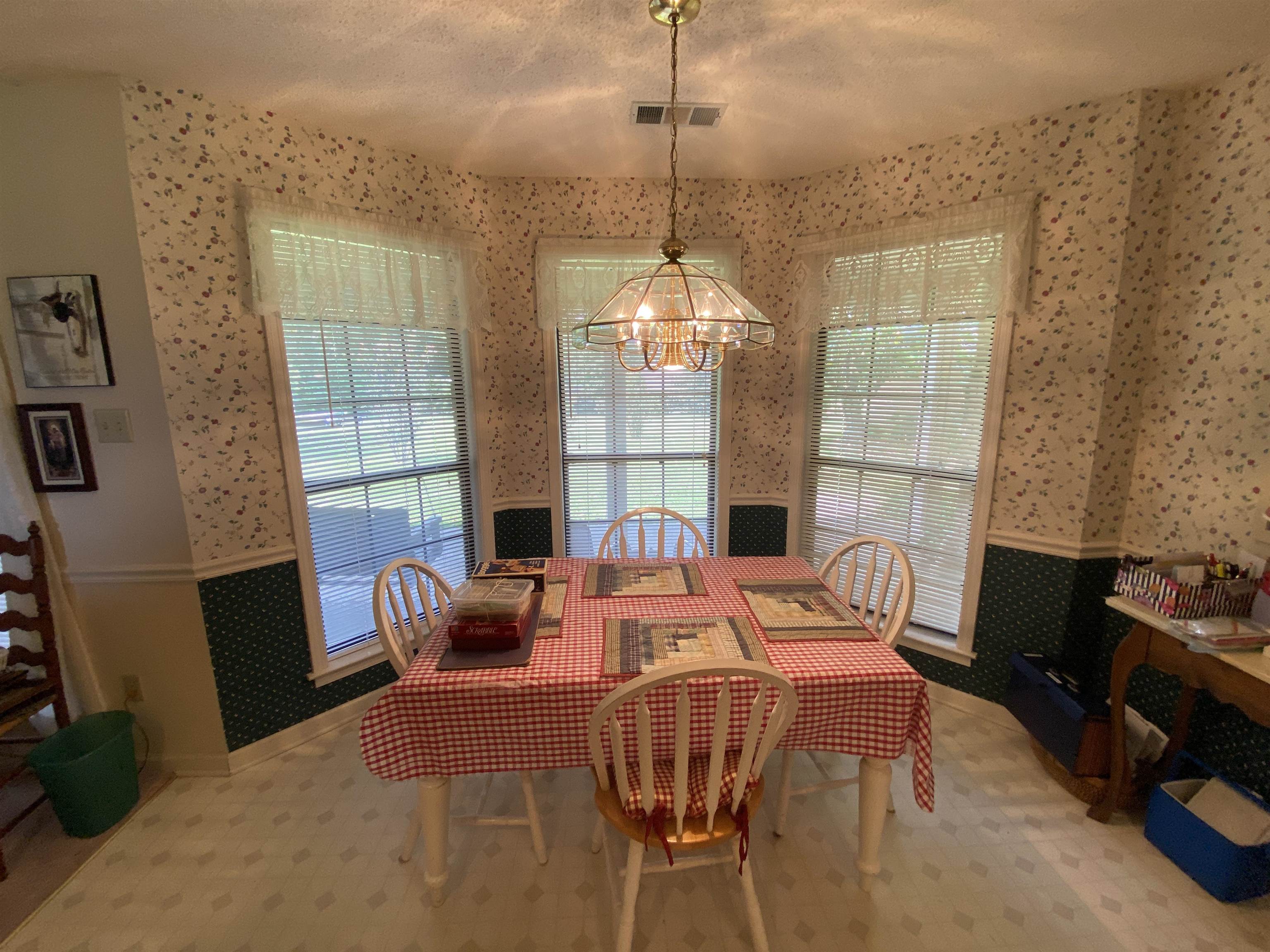 240 Sawmill Road Brighton, TN 38011 - Photo 14 of 25 Dining area with wallpapered walls, wainscoting, a chandelier, and baseboards