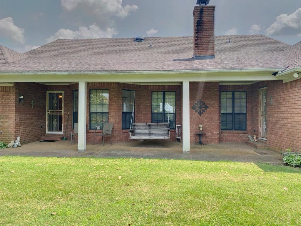 240 Sawmill Road Brighton, TN 38011 - Photo 9 of 25 Back of property featuring brick siding, a chimney, a lawn, a patio, and a shingled roof