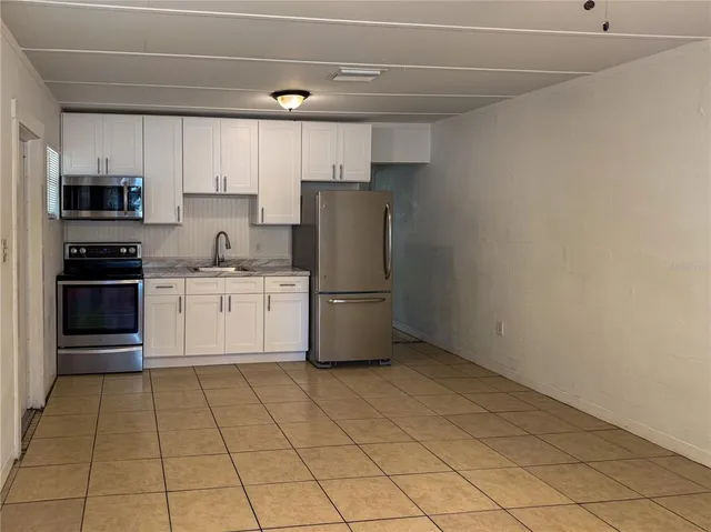 a kitchen with a sink a stove and cabinets