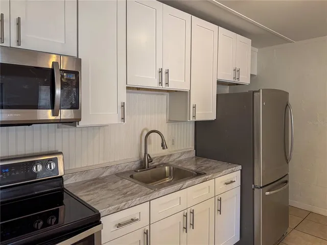 a kitchen with appliances a sink and cabinets