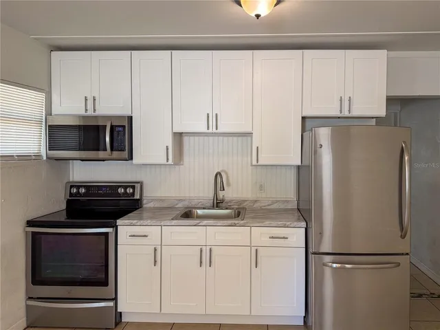 a kitchen with appliances a microwave and cabinets