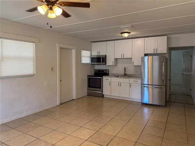 a kitchen with a refrigerator a microwave and cabinets