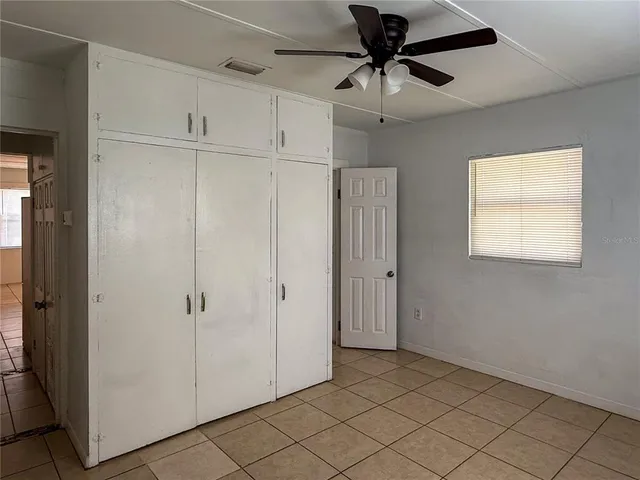 a view of a livingroom with a ceiling fan & entryway
