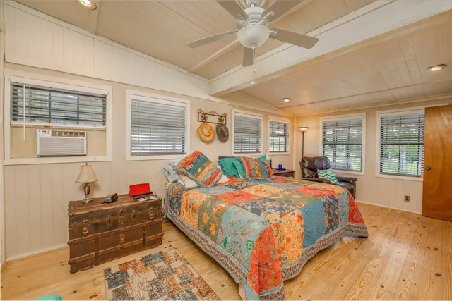 a spacious bathroom with a double vanity sink a toilet a mirror and a bathtub