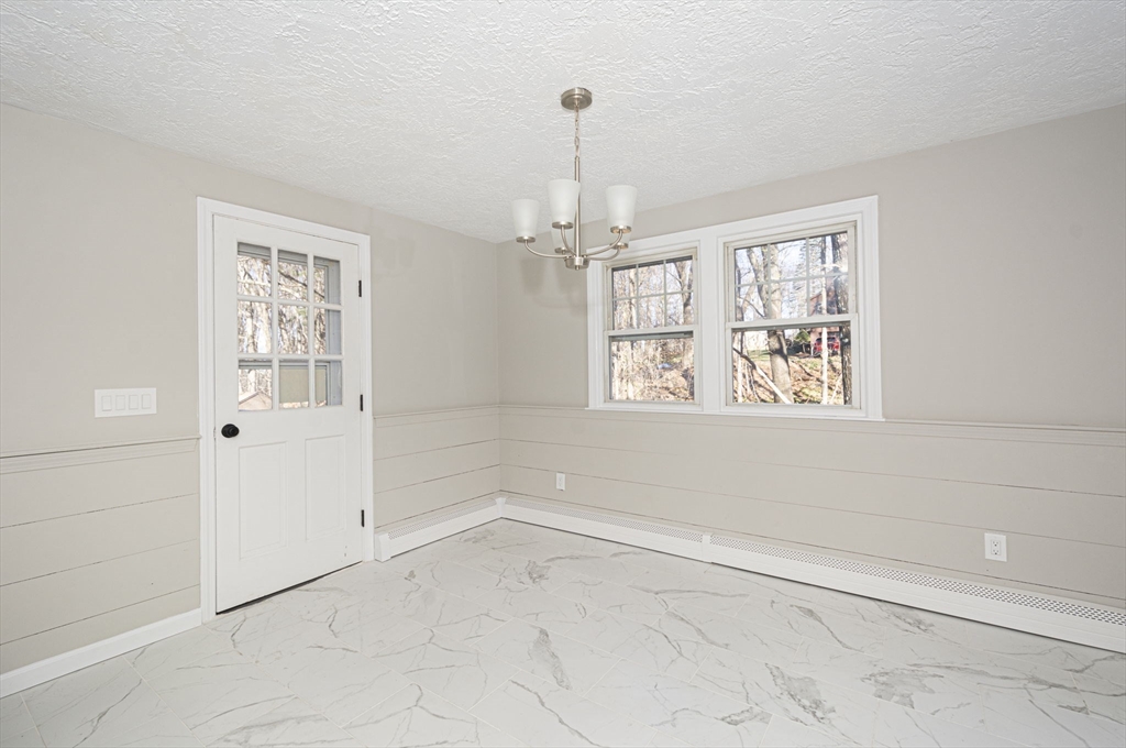 55 Dodge Road Sutton, MA 01590 - Photo 13 of 35 en empty room with windows and chandelier