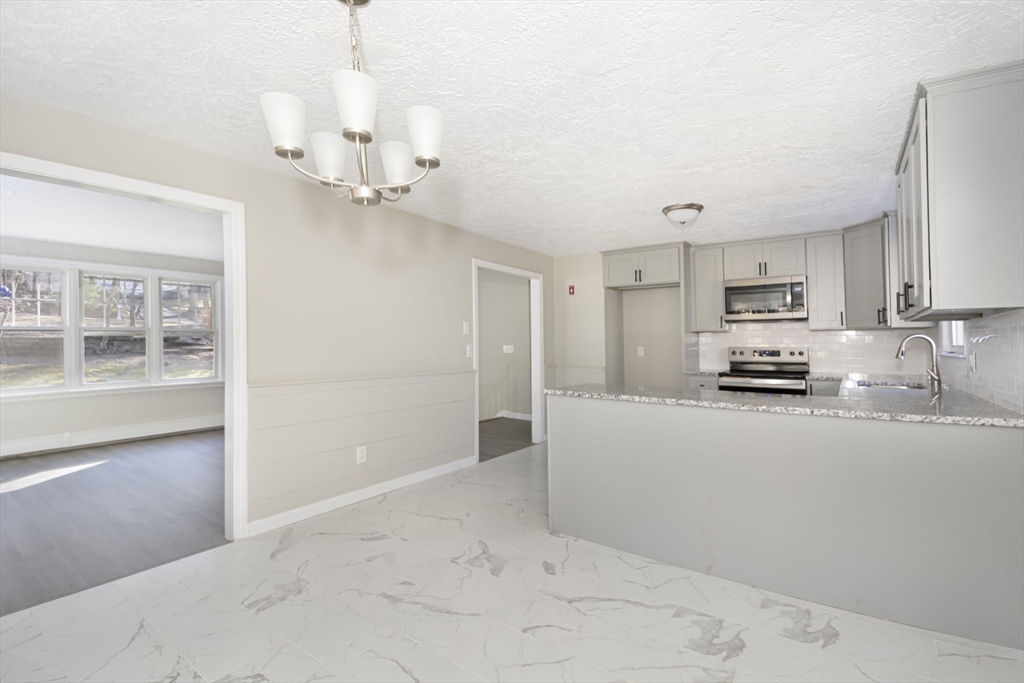 55 Dodge Road Sutton, MA 01590 - Photo 14 of 35 a kitchen with kitchen island white cabinets and stainless steel appliances