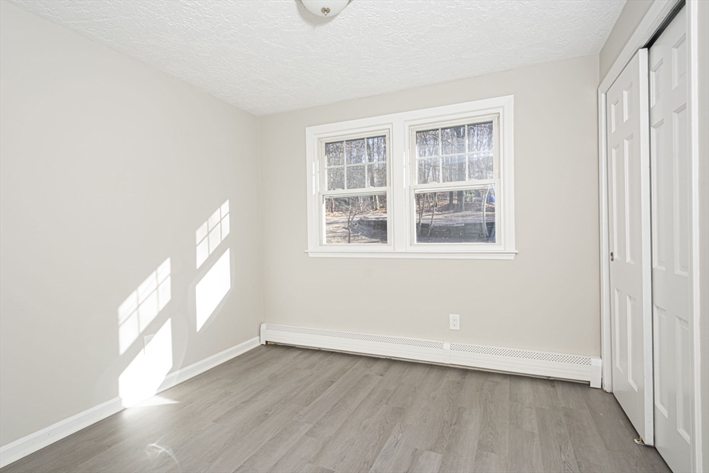 55 Dodge Road Sutton, MA 01590 - Photo 21 of 35 an empty room with wooden floor and windows
