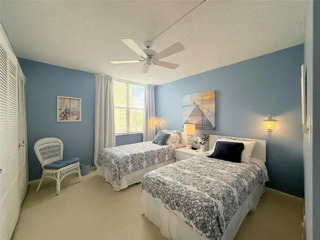 a bedroom with two beds and a chair