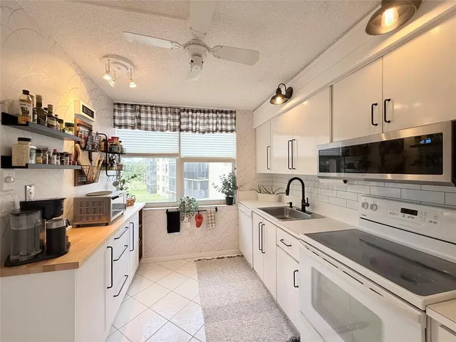 a kitchen with white cabinets and white appliances