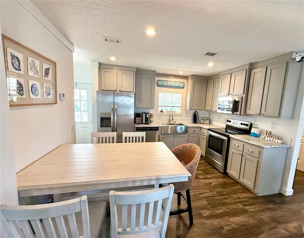 a kitchen with granite countertop a stove a sink and a refrigerator